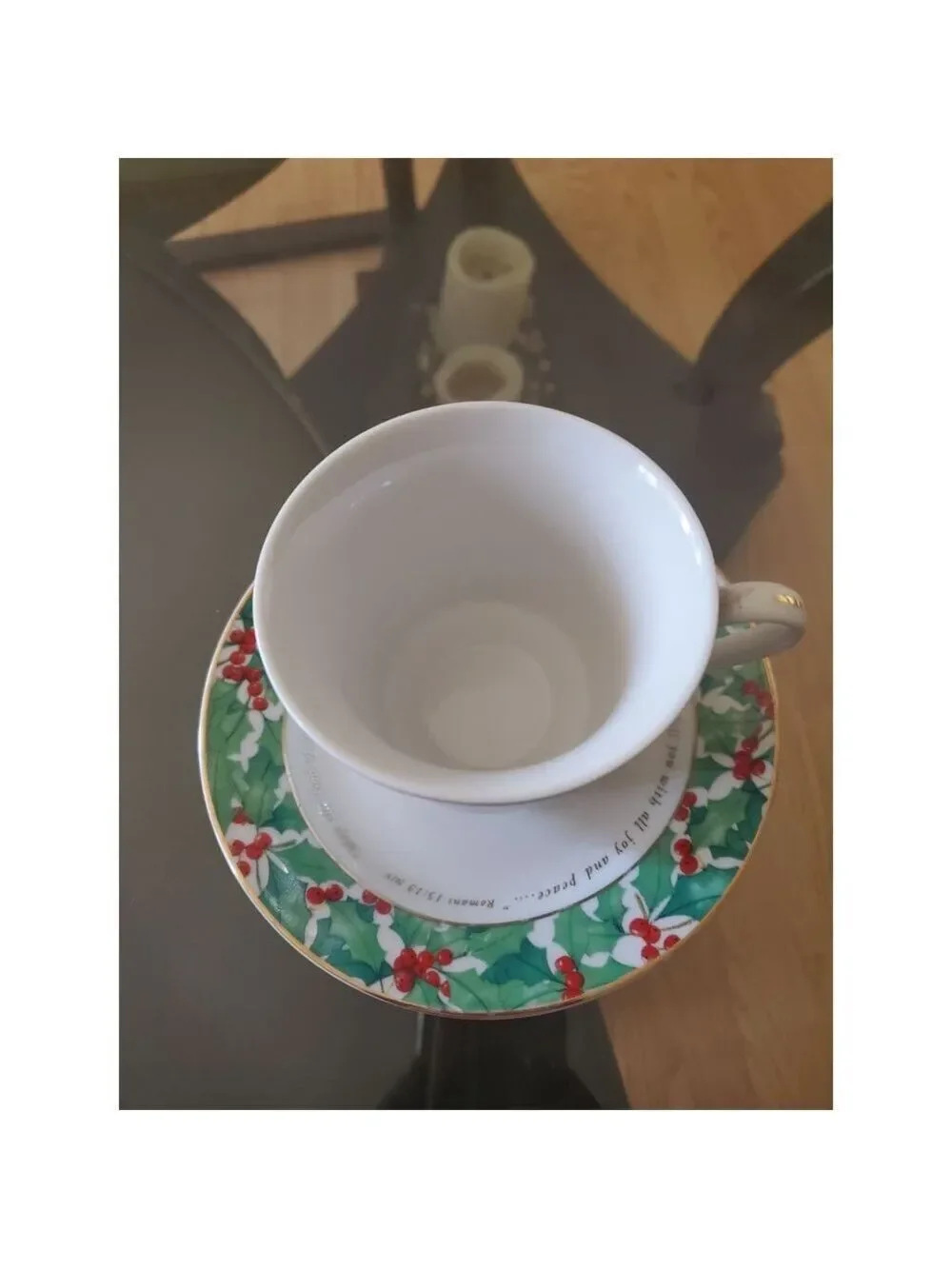 vintage teacup and saucer set features a festive holly pattern.